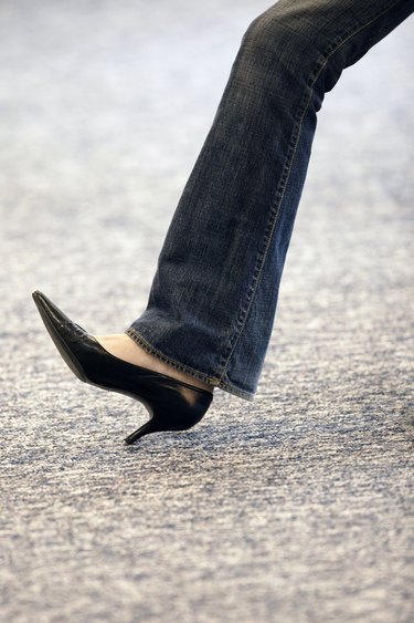 Leg of woman wearing high heels and jeans