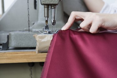 Hand using sewing machine on fabric