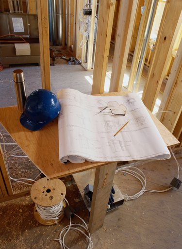 Blueprint and a Hard Hat Inside a Building Frame