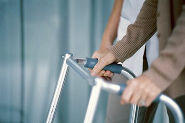 Man with walker being assisted by medical professional