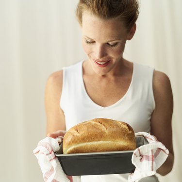 Young woman looking at a loaf of freshly baked bread