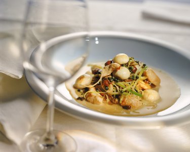 Plate of vegetable with scallops and wine glass