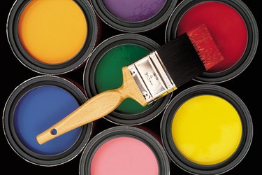 Assorted colors of paint in cans with brush