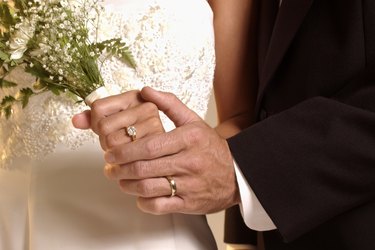 Hands with wedding rings and bouquet