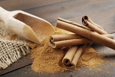 Cinnamon sticks and powder in wooden scoop