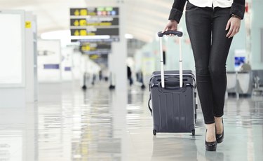 Young woman pulling luggage at the airport