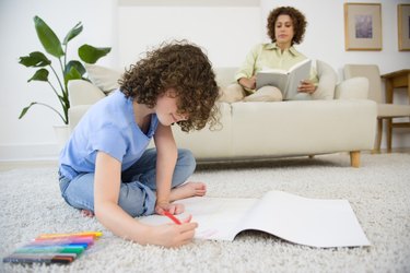 Daughter coloring with mother reading