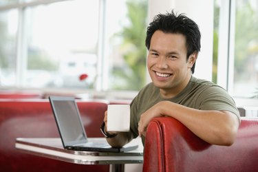 Asian man sitting in diner booth