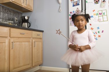 Girl in ballerina costume in kitchen