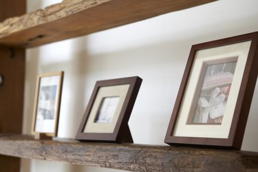 Framed photos on wooden shelf, close-up