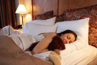 Woman sleeping in hotel bed