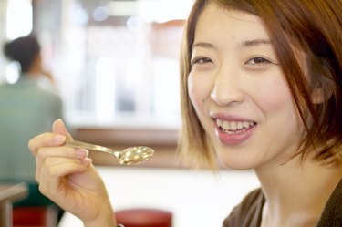 Woman holding spoon in restaurant