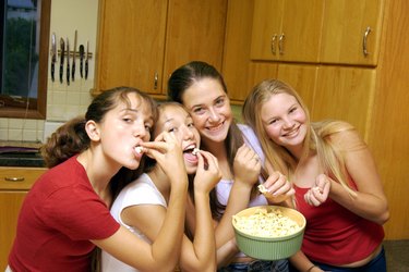 Teenage girls eating popcorn