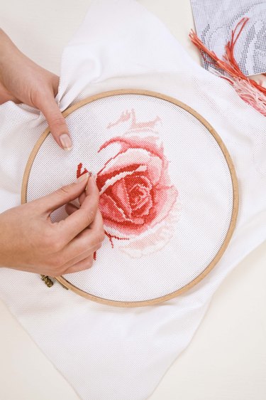 Woman cross stitching rose