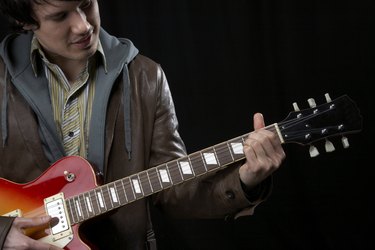 Shot in the UK, man playing a guitar