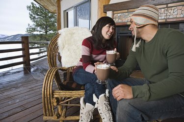 Couple drinking hot cocoa on deck