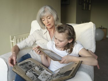 Grandmother and granddaughter (9-11) looking at photo album