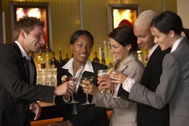 Businesspeople holding drinks in bar