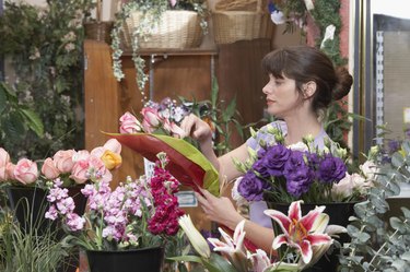 Side profile of a female florist preparing a bouquet in a flower shop