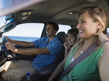 Smiling family riding in minivan