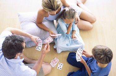 High angle view of family playing cards on floor