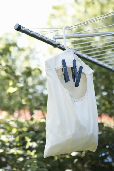 Bag of clothespins hanging from clothesline outdoors