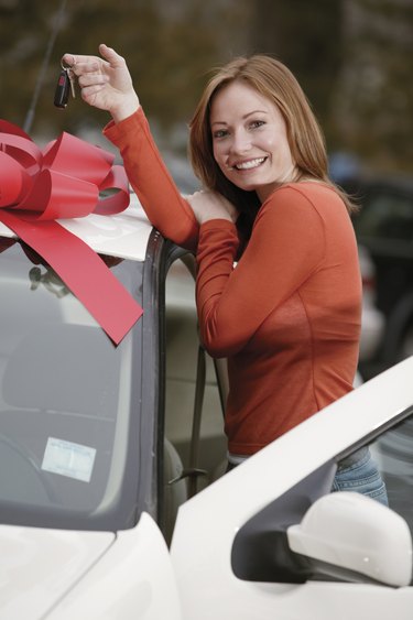 Woman holding keys to new car