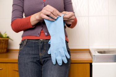 Woman's hands holding rubber gloves