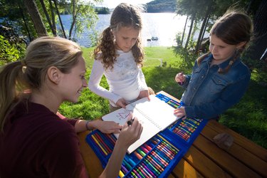 Mother and daughters drawing outdoors