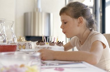 Girl blowing out candles on birthday cake