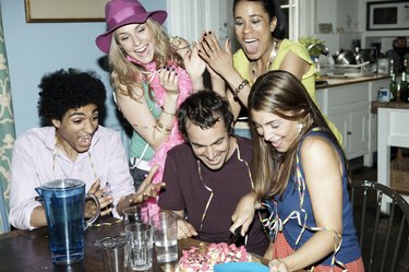 Group of friends cutting a cake