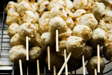 Thailand, Bangkok, unusual delicacies found at street vendor food stalls, skewers of chicken meatballs.