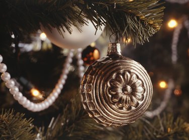 Silver Christmas ornament hanging from Christmas tree, close-up