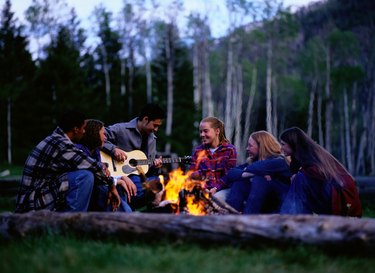 Teen Friends Singing Around Campfire