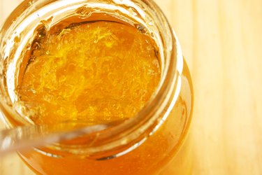 Top angle view of a spoon in a jar of marmalade