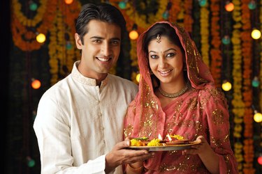 Portrait of a man and woman holding a pooja thali