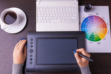 Designer working desk filled with computer,pen tablet