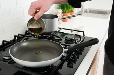 Man pouring cooking oil into frying pan