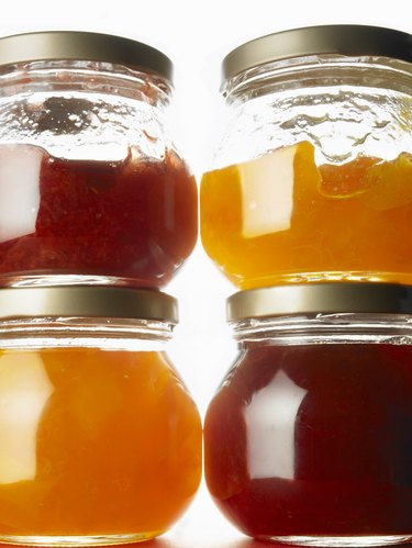 Four jars of jam, close up, white background