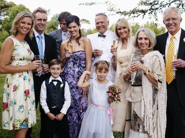 Bride and groom with wedding guests, smiling, portrait