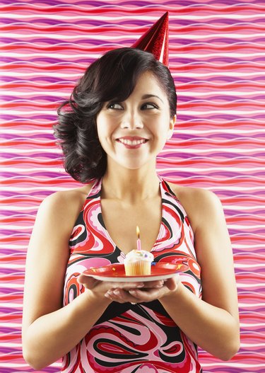 Native American woman holding birthday cupcake