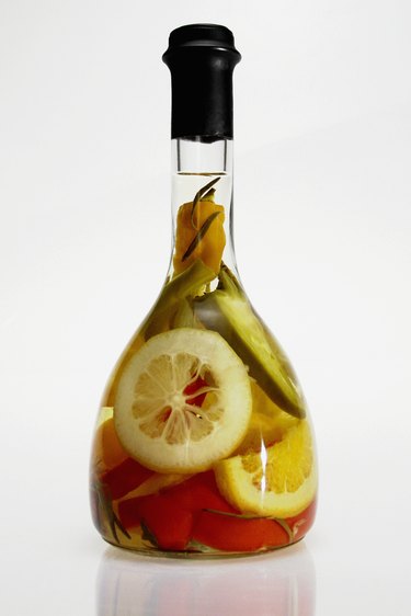 Bottle of olive oil with fruit and vegetables, close-up