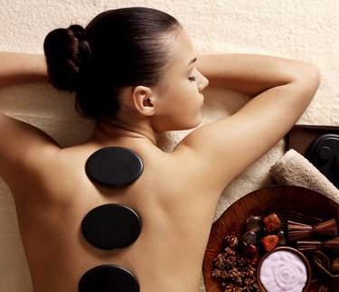 woman having stone massage in spa salon