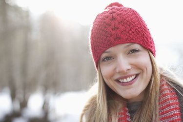 Close up portrait of smiling woman wearing red knit hat