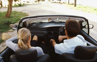 Rear view of young couple traveling in car