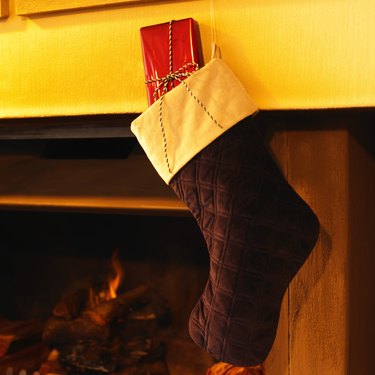 Christmas stocking hanging over a fireplace containing a gift