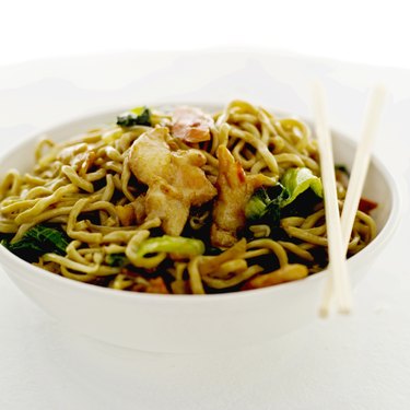 close-up of chinese noodles in a bowl and a pair of chopsticks