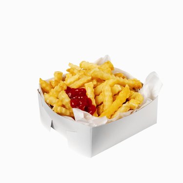 Close-up of a carton of french-fries with ketchup