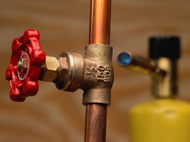 Shut-off valve on copper pipe; blowtorch in background