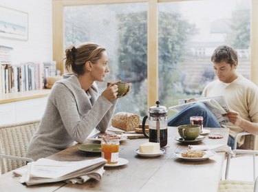 Couple Sits at a Kitchen Table Having Breakfast